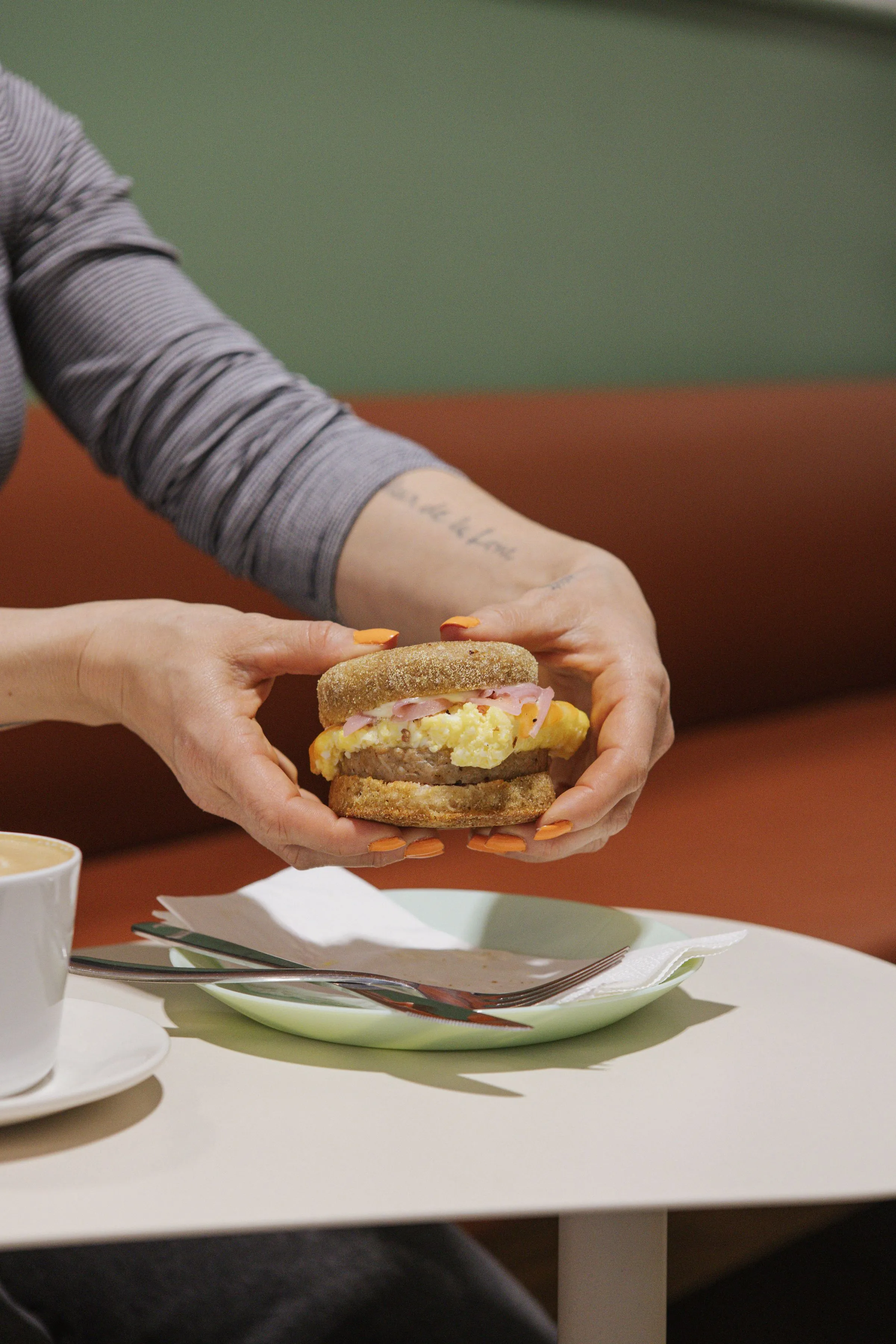A pair of hands holding a breakfast sandwich