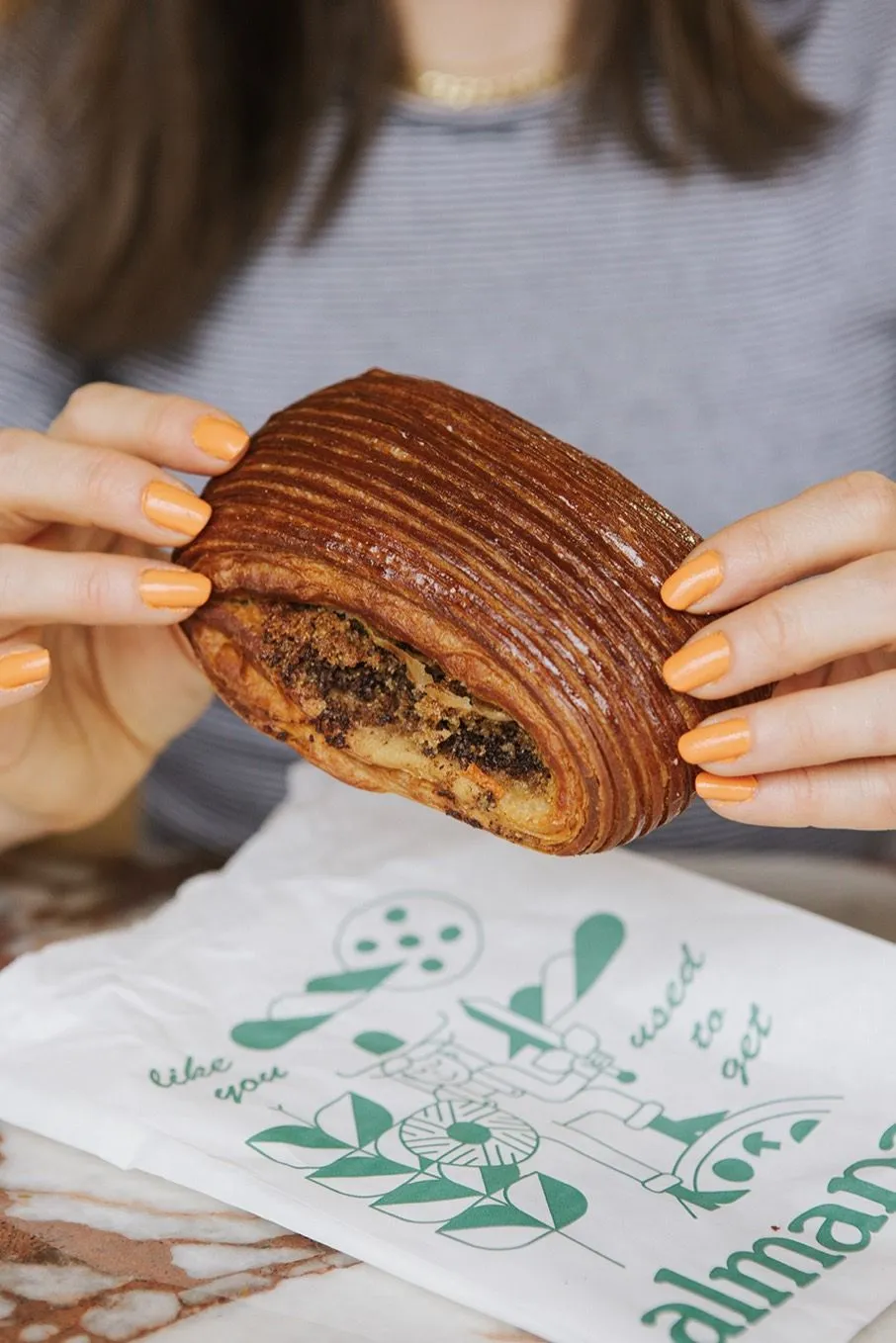 Hands tearing open a laminated pastry.