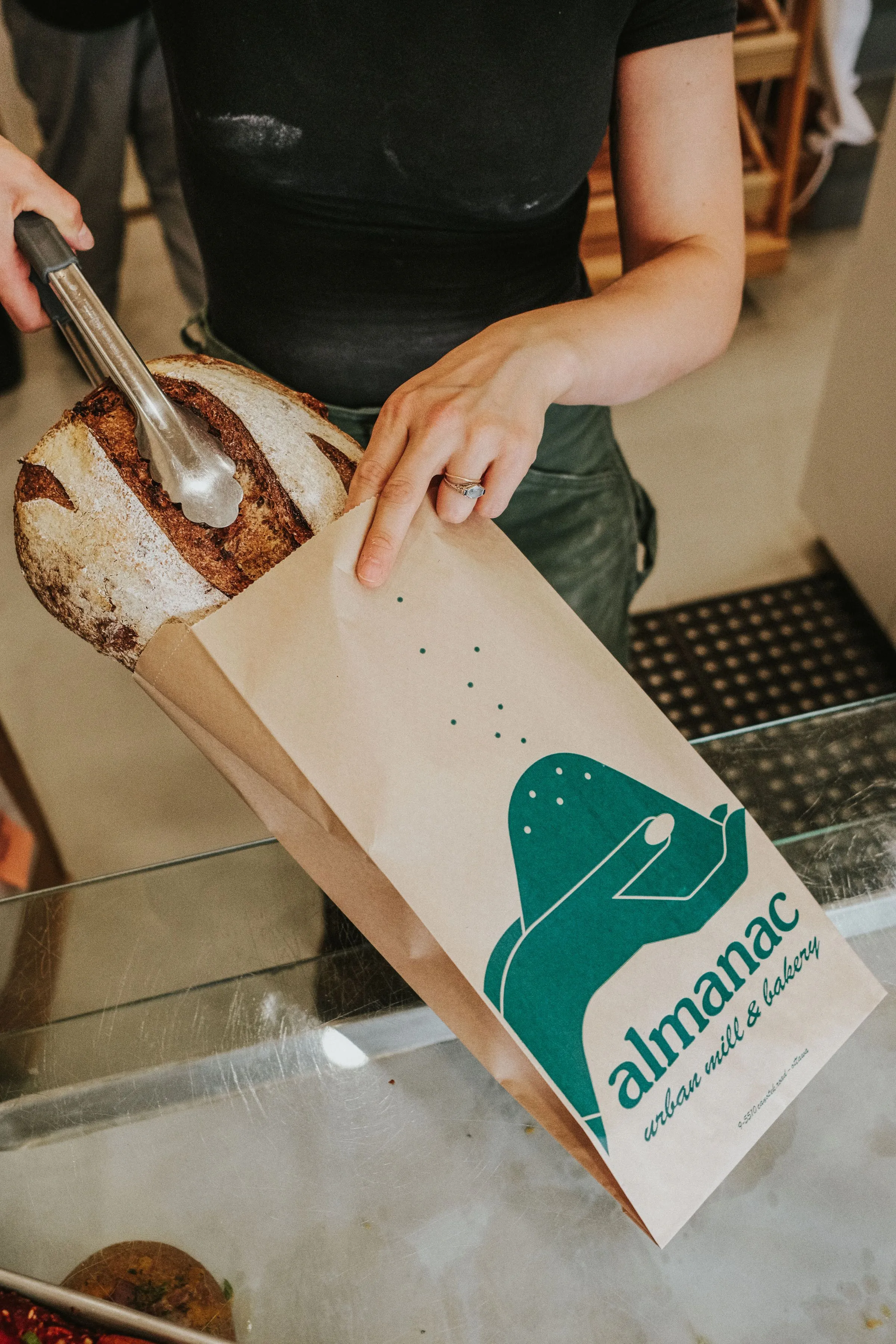 A loaf of fresh-milled sourdough bread being bagged at the Canotek Counter.